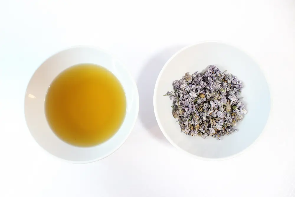 image of a bowl of oil and a bowl of lilac flowers to make infused lilac oil