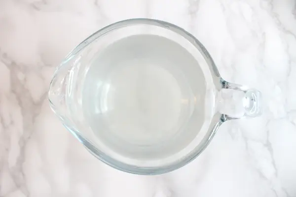 a glass jar of water with dissolved magnesium flakes
