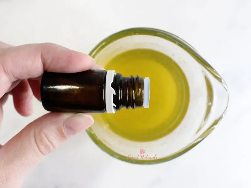 photo of adding essential oil to melted ingredients for diy hair conditioner in glass jar