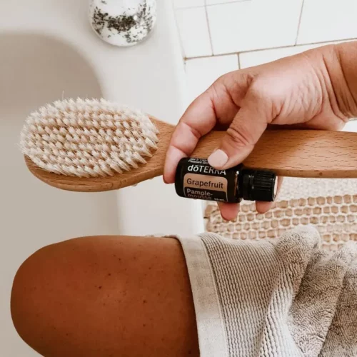 woman in bathtub with dry brush and grapefruit essential oil