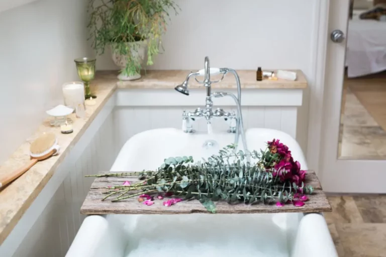 beautiful photo of self care bath with roses, essential oils, and candles