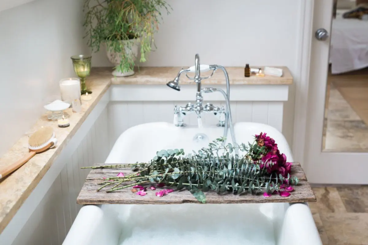 beautiful photo of self care bath with roses, essential oils, and candles
