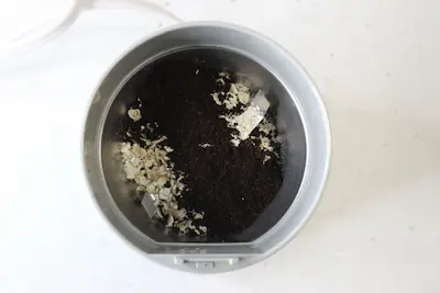 coffee grinder with unground oatmeal and coffee in it for use in making coffee oatmeal body scrub