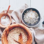 bowls of oatmeal, salts and essential oils for making a diy oatmeal bath soak