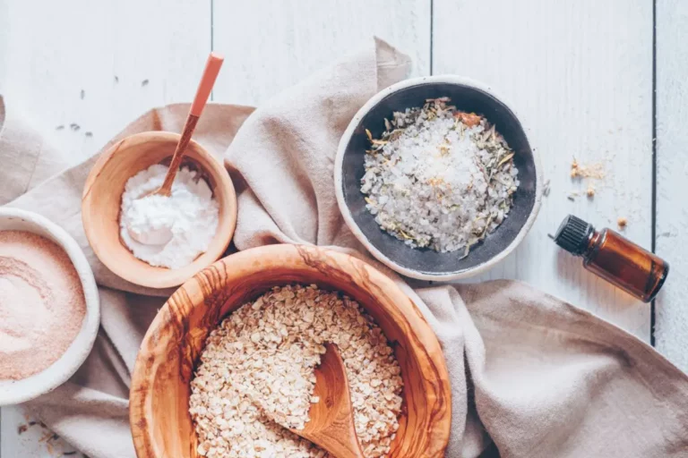 bowls of oatmeal, salts and essential oils for making a diy oatmeal bath soak