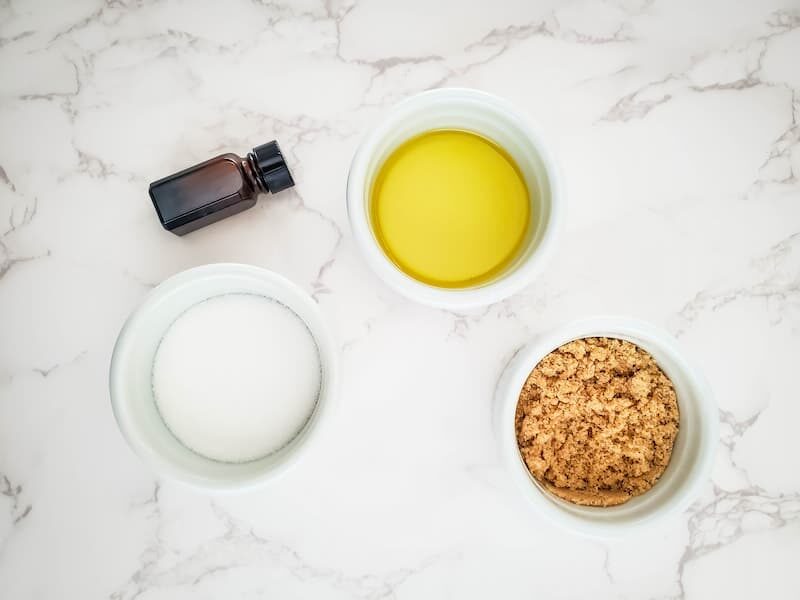 bowls of sugar, carrier oil and essential oil for making a homemade fall sugar scrub