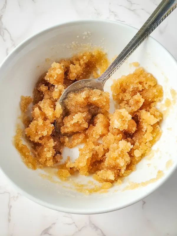 a bowl of ingredients to make a sugar scrub being stirred