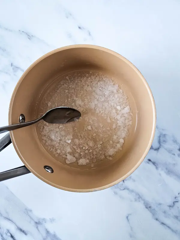 pot of boiling water with magnesium flakes added to make homemade lotion