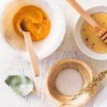 a bowl of organic honey, yoghurt, honey and a spoon to make a hydrating face mask
