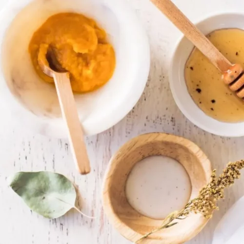 a bowl of organic honey, yoghurt, honey and a spoon to make a hydrating face mask