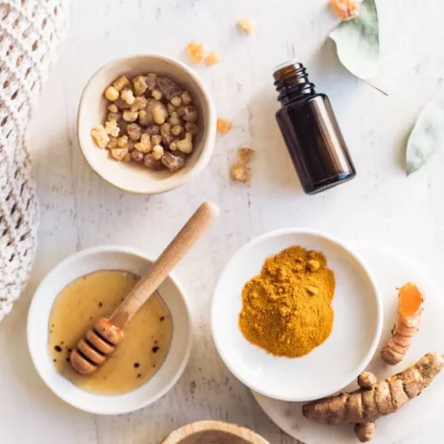 a group of bowls with turmeric, honey, and essential oil to make a turmeric face mask