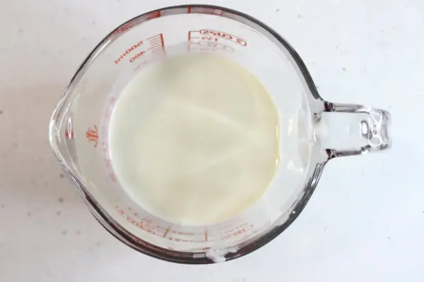 glass measuring cup with mixture in it for homemade sunscreen
