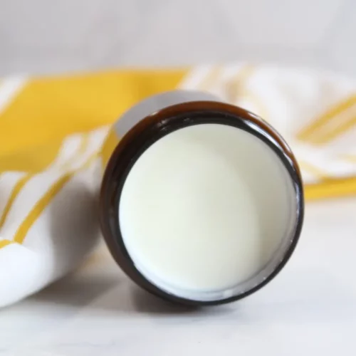 a jar of homemade natural sunscreen on a towel