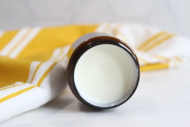 a jar of homemade natural sunscreen on a towel
