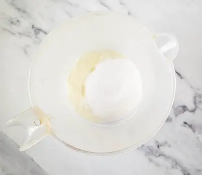 measuring cup with ingredients for making sugar scrub cubes