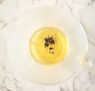 a bowl of melted butters, oils and vanilla bean powder for making lotion bars