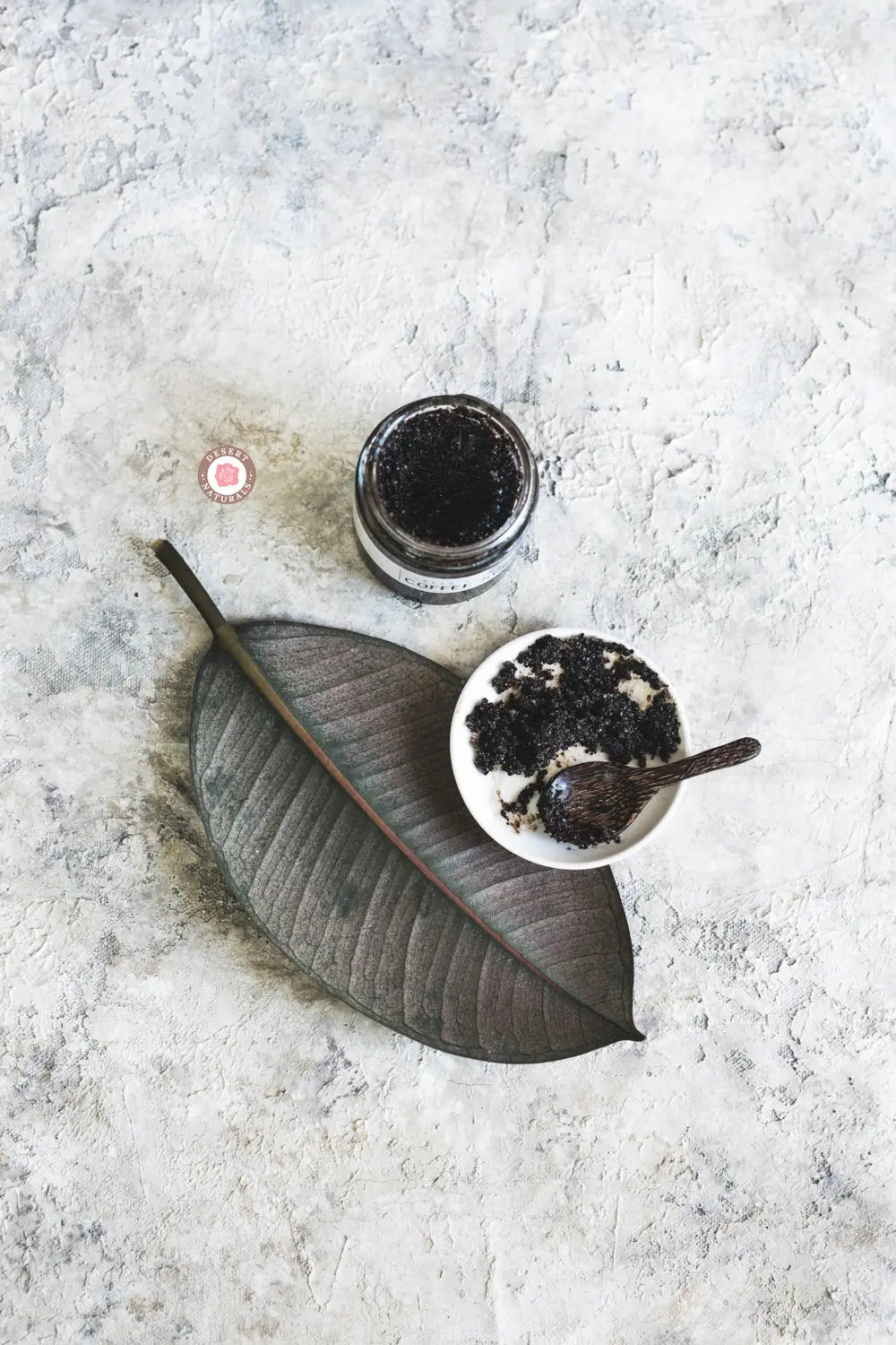jar of homemade coffee scrub on a leaf