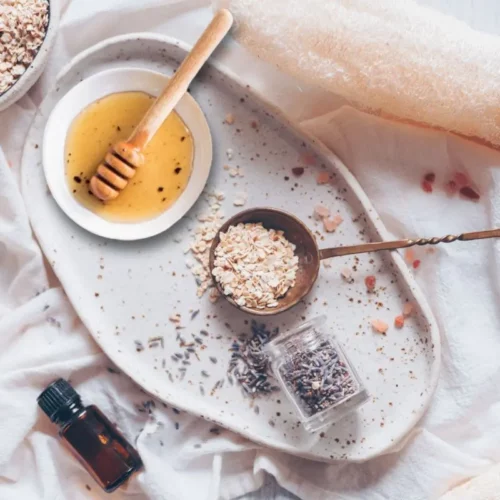a bowl of oatmeal with honey and lavender essential oil on a white plate