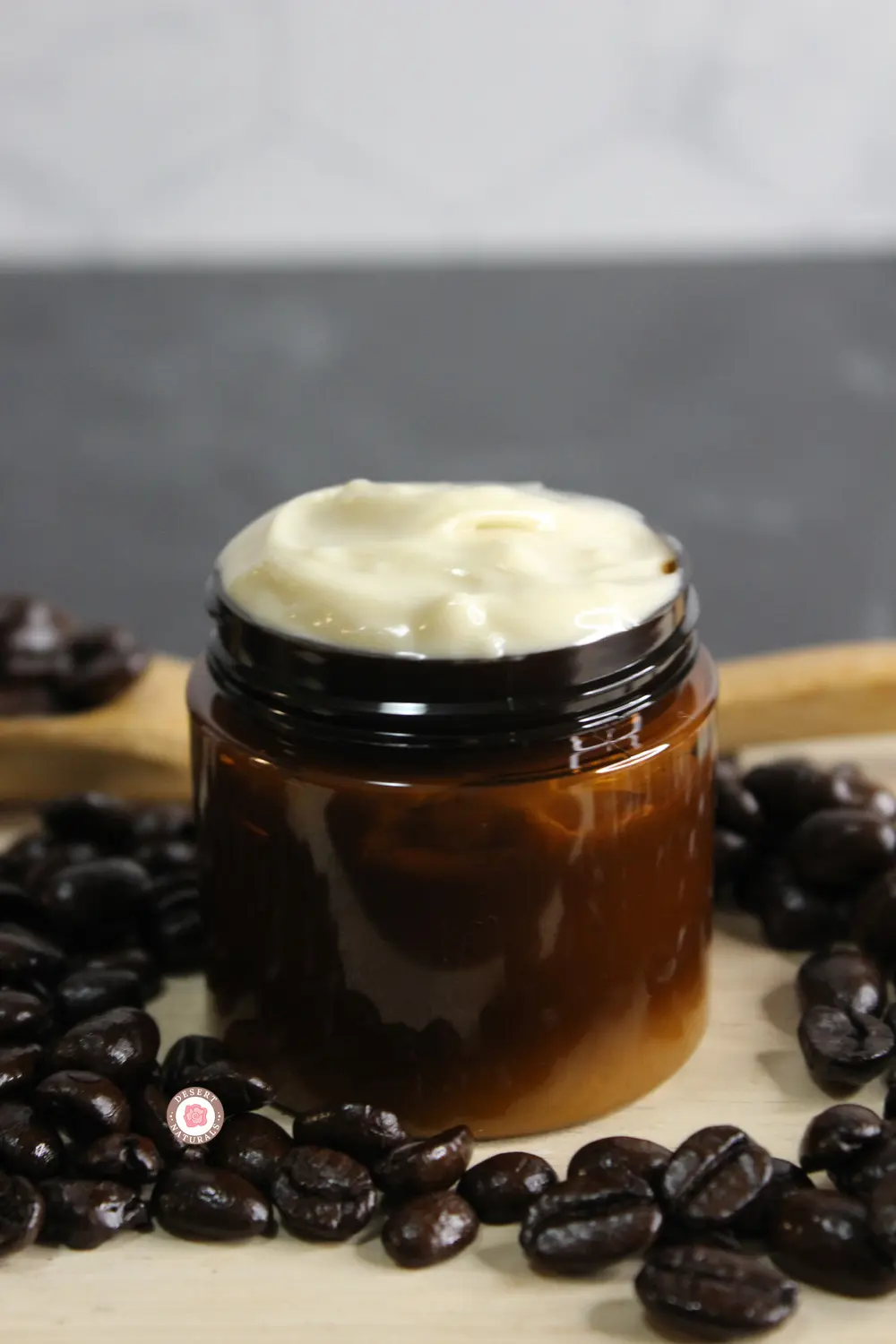 jar of homemade coffee eye cream surrounded by coffee beans