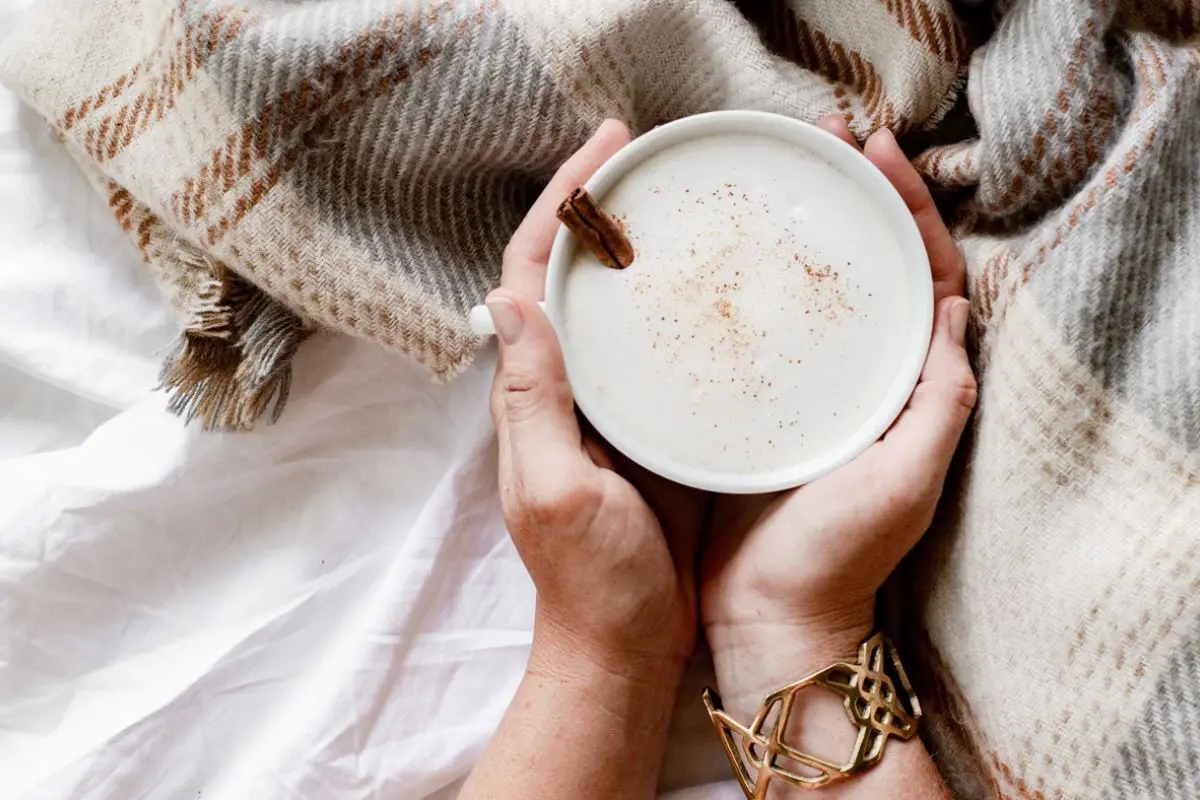 a person holding a cup of pumpkin latte