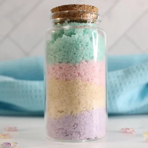 a glass jar with colorful rainbow bath salts in it