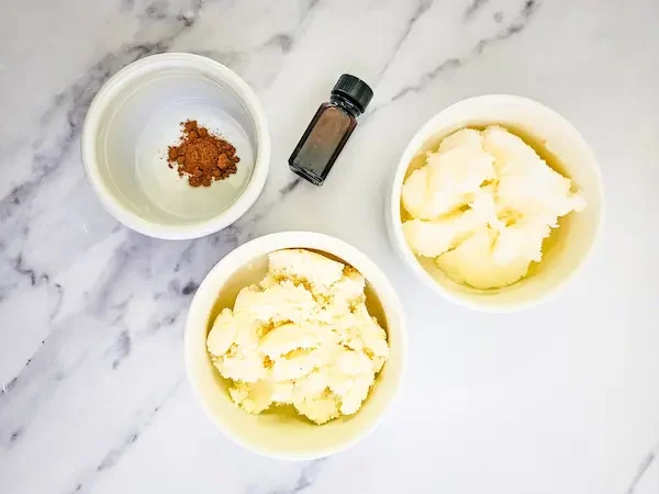 bowls of butters and essential oils needed to make homemade gingerbread body butter