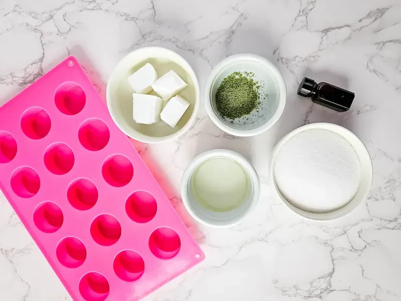 supplies and bowls of ingredients needed to make green tea sugar scrub bars
