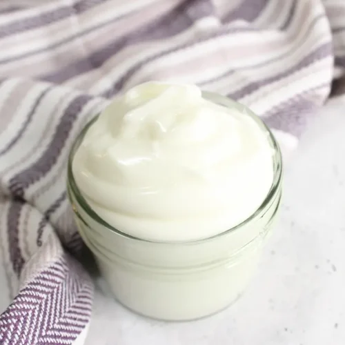 jar of diy tallow balm with a purple striped towel