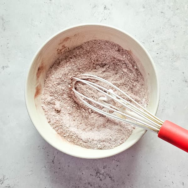 bowl of ingredients with a whisk for making gingerbread shower bombs