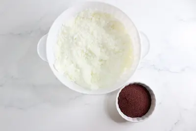 a bowl of bath bomb mixture and a bowl of hibiscus powder