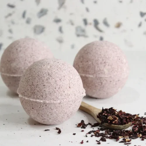 homemade hibiscus bath bombs on white background with dried hibiscus flowers