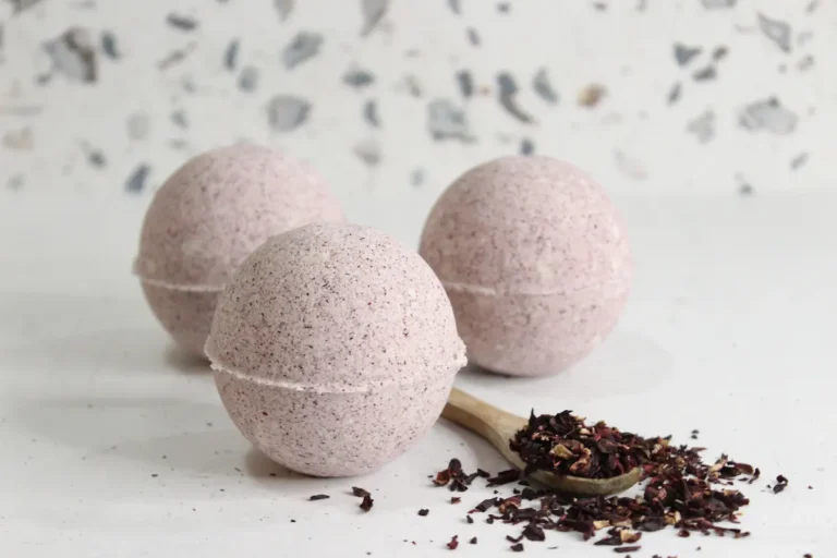 homemade hibiscus bath bombs on white background with dried hibiscus flowers