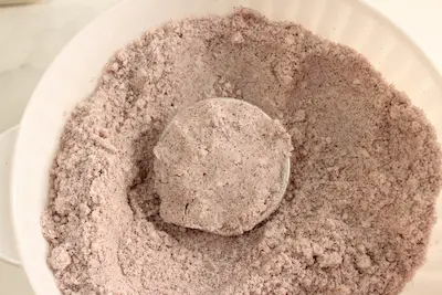 a bowl of hibiscus bath bomb mixture with a filled bath bomb mold 
