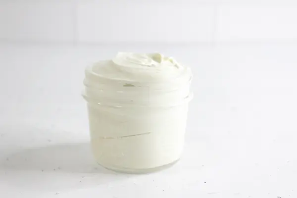glass jar of homemade diaper rash cream on a white background