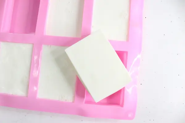 homemade tallow soap in a soap mold with one soap popped out