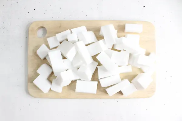 melt and pour soap base cut into small squares on a wooden cutting board for making tallow soap
