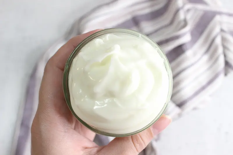 hand holding a jar of homemade whipped tallow balm