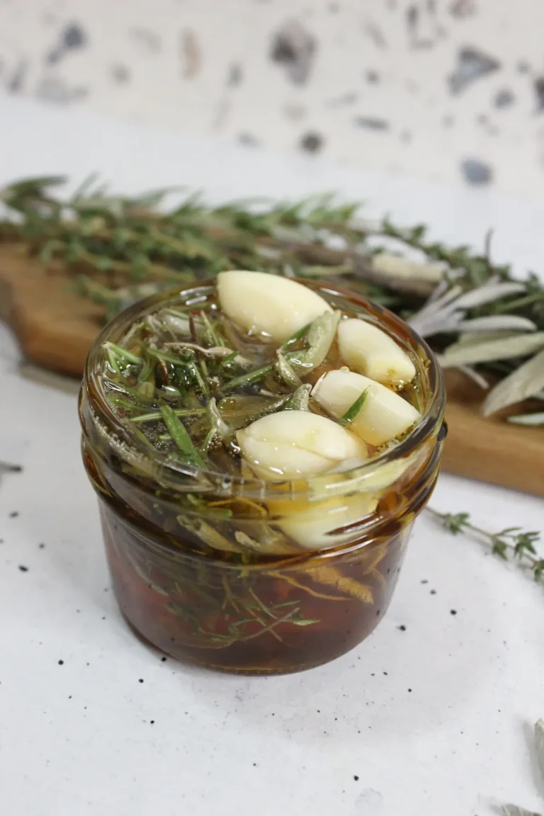 jar of homemade herb infused honey with garlic and dried herbs