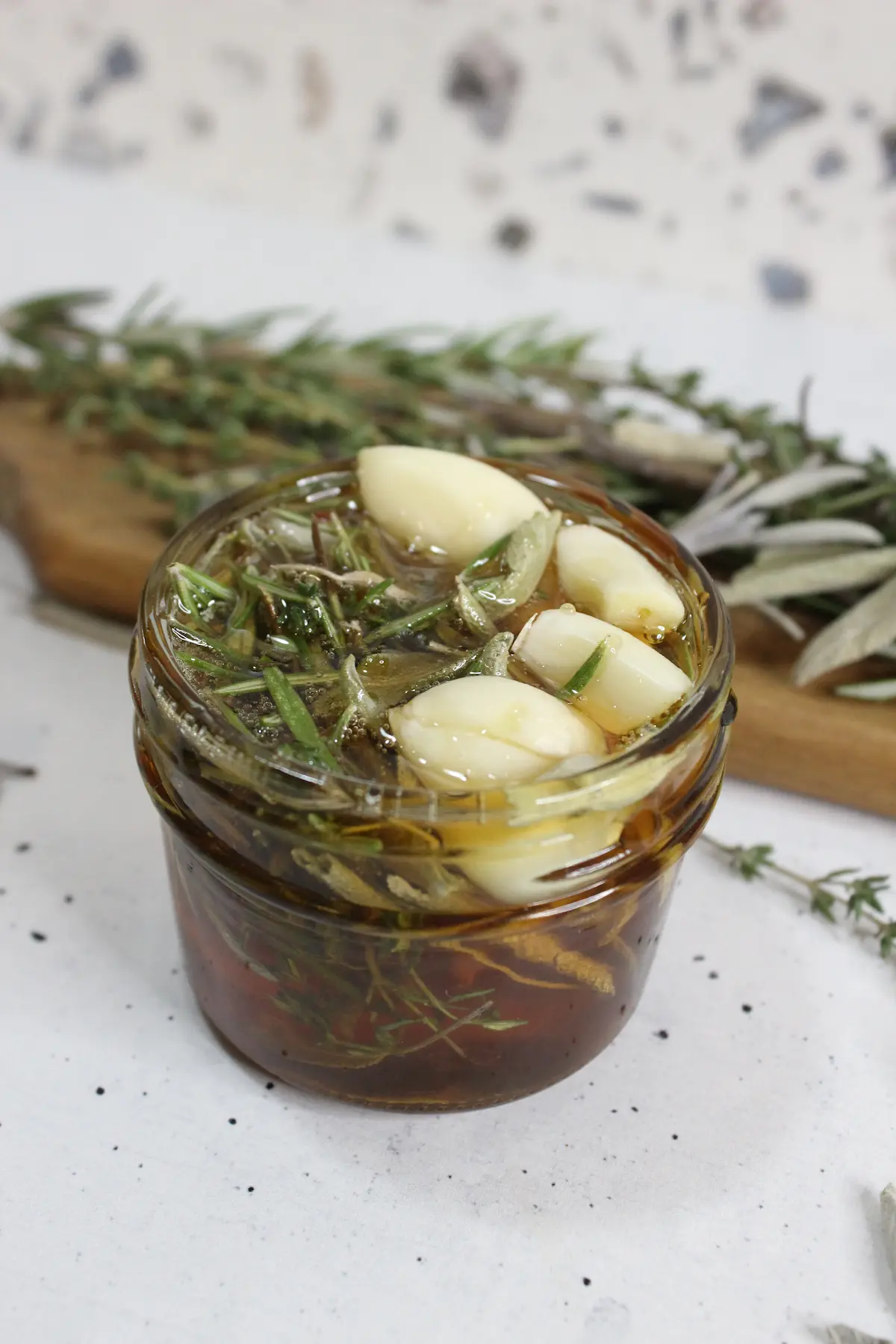 jar of homemade herb infused honey with garlic and dried herbs