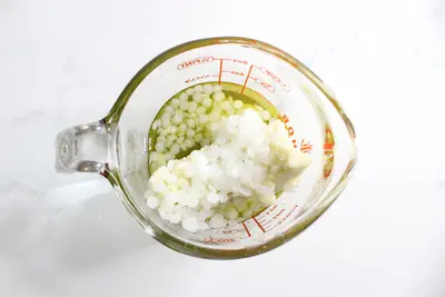 jar of tallow, beeswax, shea butter before being melted for a tallow stick diy