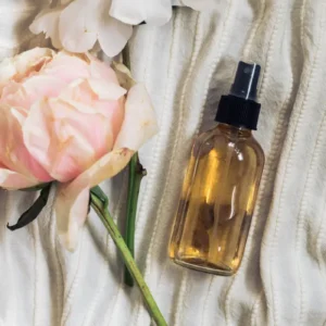 homemade linen sleep spray bottle on cream colored duvet with roses