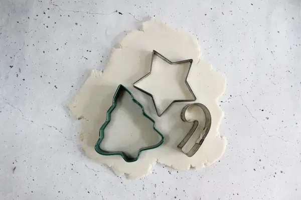 rolled out no bake diffuser dough with Christmas cookie cutters placed on it