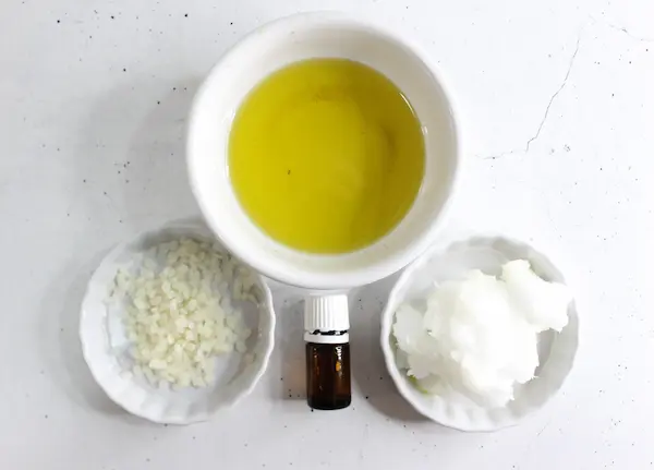 bowls of butters, wax, and essential oil needed to make homemade sleep salve