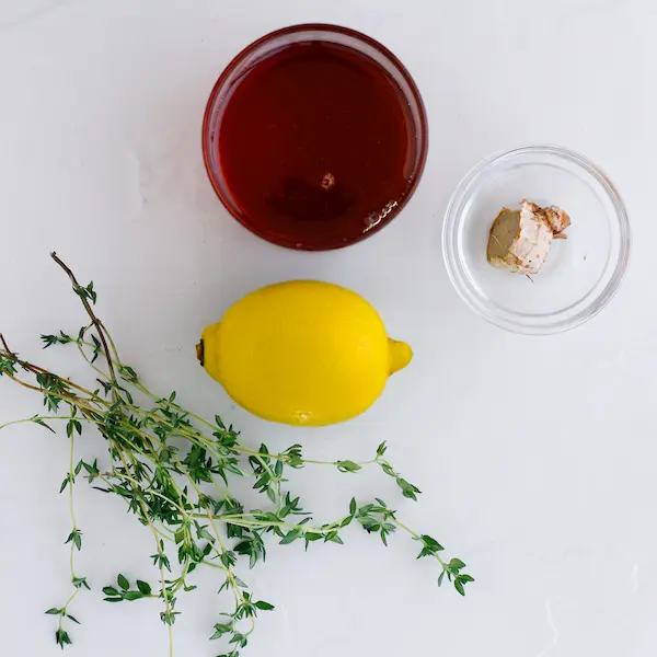 Thyme Cough Syrup With Honey Lemon & Ginger DIY Recipe 12 a lemon, honey, ginger, and thyme on a white background for making a homemade cough syrup