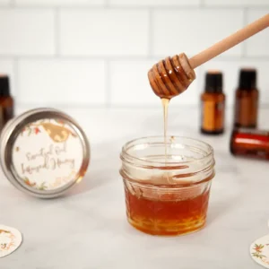 jar of honey with bottles of essential oil in the background