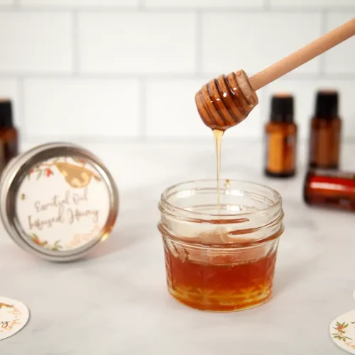 Essential Oil Infused Honey Respiratory Syrup Recipe 23 jar of honey with bottles of essential oil in the background