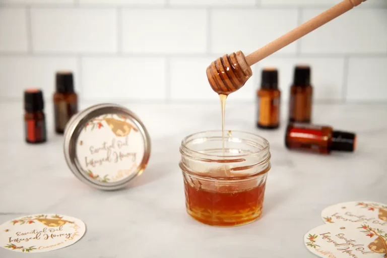 jar of honey with bottles of essential oil in the background