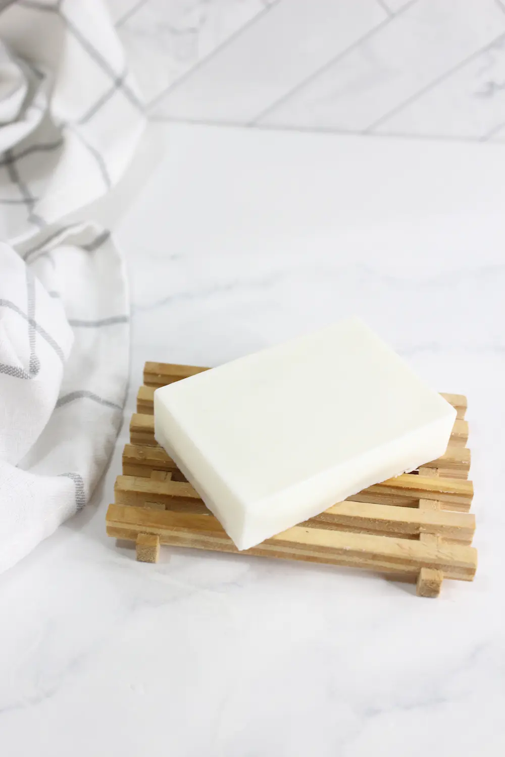 bar of homemade tallow soap on wooden soap holder