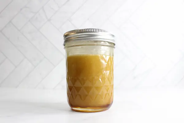 jar containing mixed ingredients for a honey calendula facial cleanser