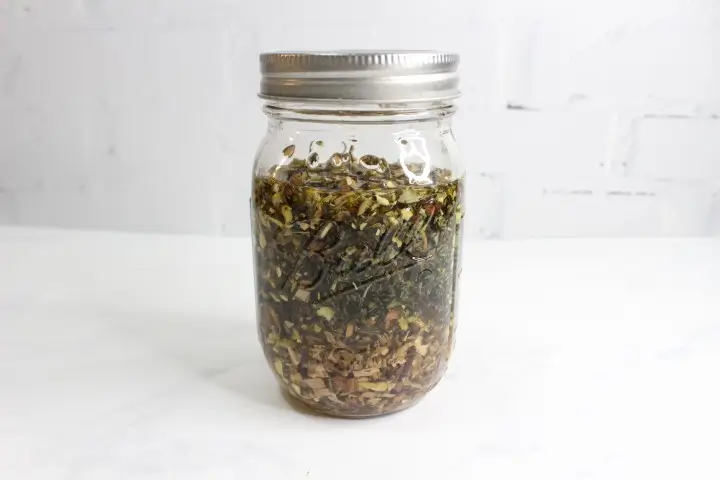 DIY Herbal Headache Relief Balm Recipe with Essential Oils 13 jar of herbs and carrier oil to make an infused oil for a diy headache relief salve